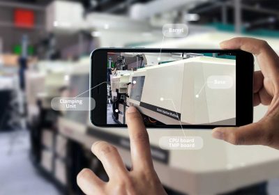 Augmented reality concept. AR. Industrial 4.0 , Hand of engineer holding mobile smart phone using virtual AR to check the work of electric machine on smart factory background.